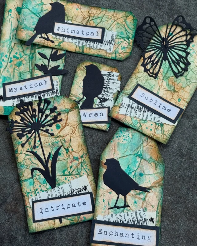 ✨A little peek at today’s paper play…✨ Which is your fav? 
I’ve been a busy creator making this set of grungy, mystical tags using tissue paper, Salvaged Patina Distress Ink, and some of my favorite Tim Holtz die cuts. The texture turned out beautifully crinkled, with inky layers and stitched scraps adding that extra dose of whimsy.

Each tag is a tiny mood—Mystical, Whimsical, Enchanting, Intricate… simple little pieces that capture a feeling or a flicker of inspiration.

Hope this inspires you to pull out your scraps and get a little messy 💙🐦‍⬛